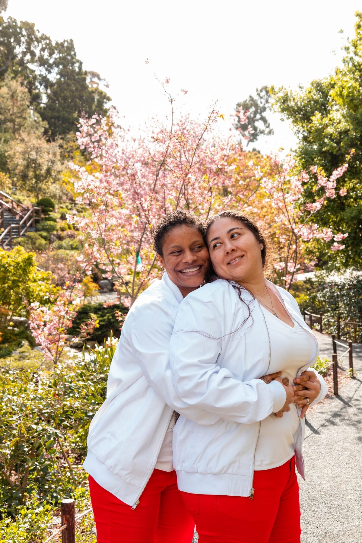 Couple embracing beneath blooming cherry trees
