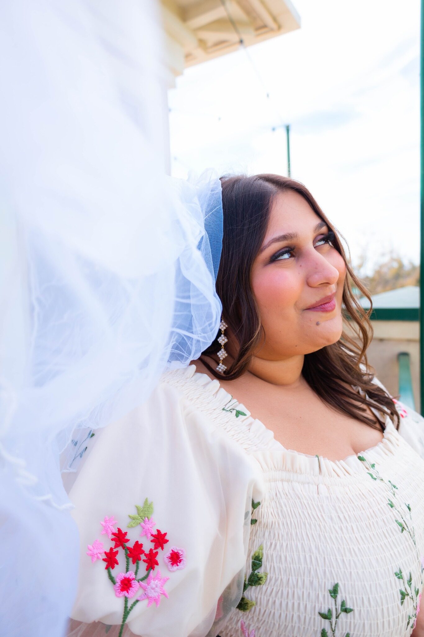 Bride-to-be looking up with her veil beside her