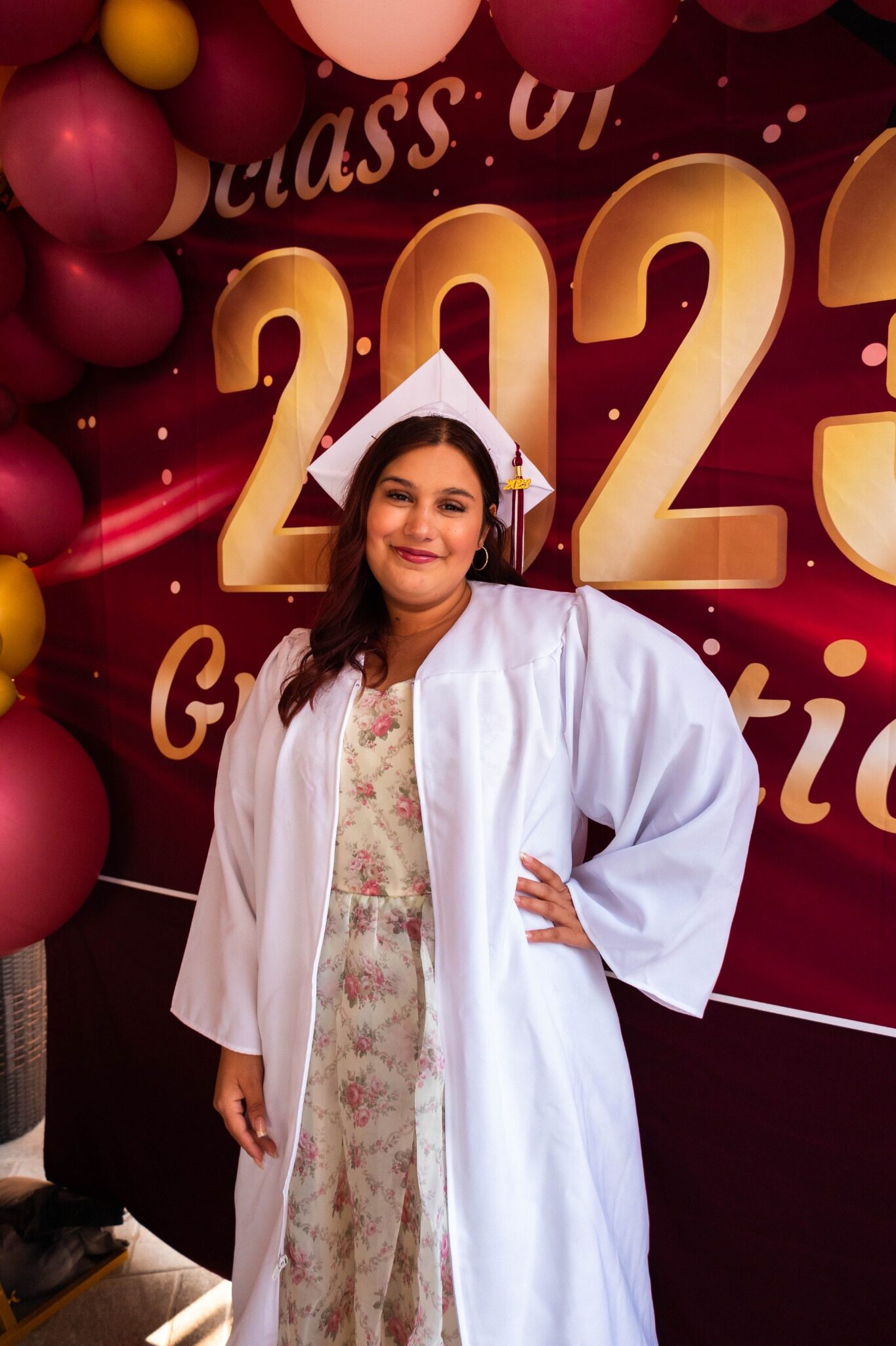 Graduate celebrating in front of a Class of 2023 backdrop