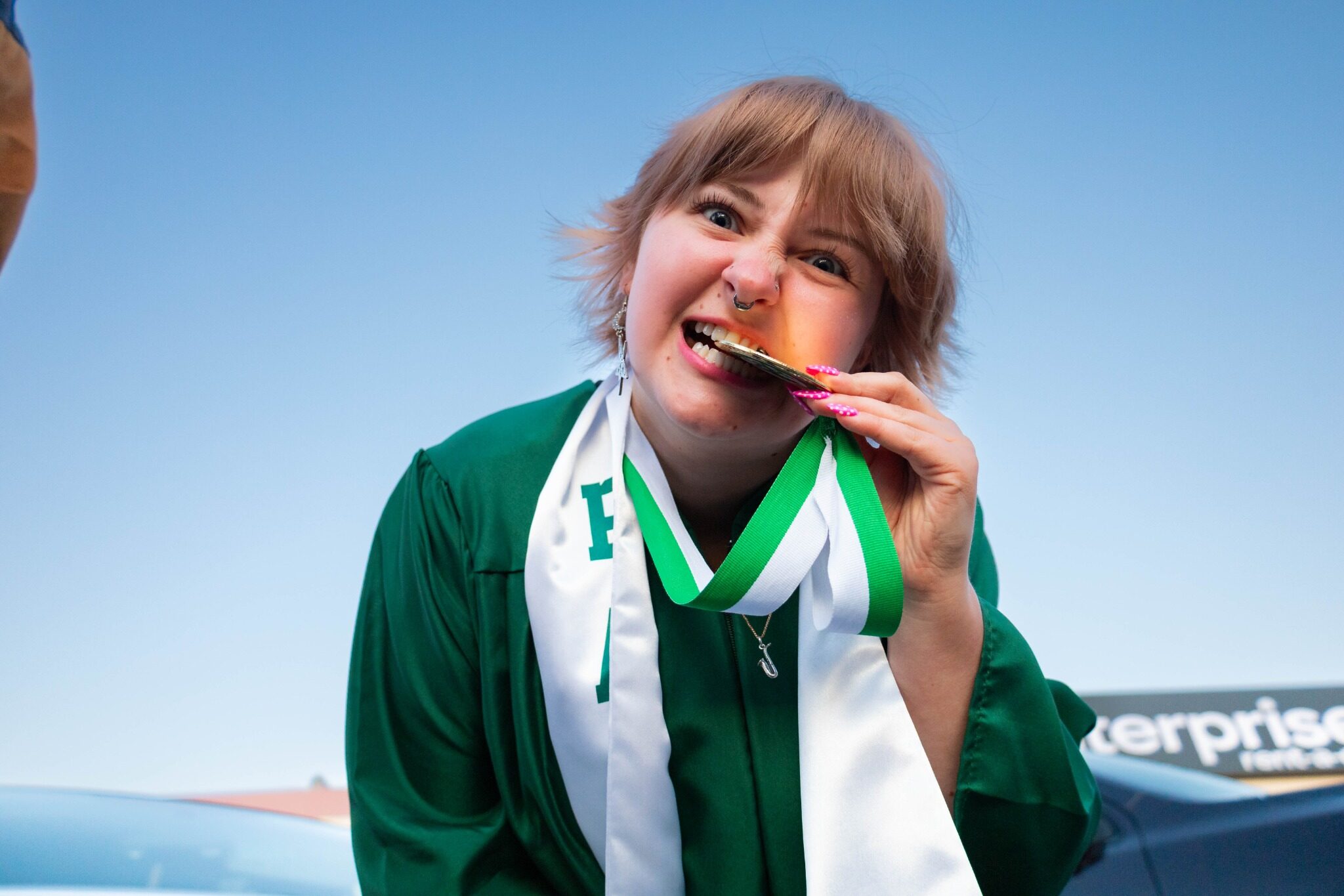 Graduate playfully biting a watermelon slice after commencement