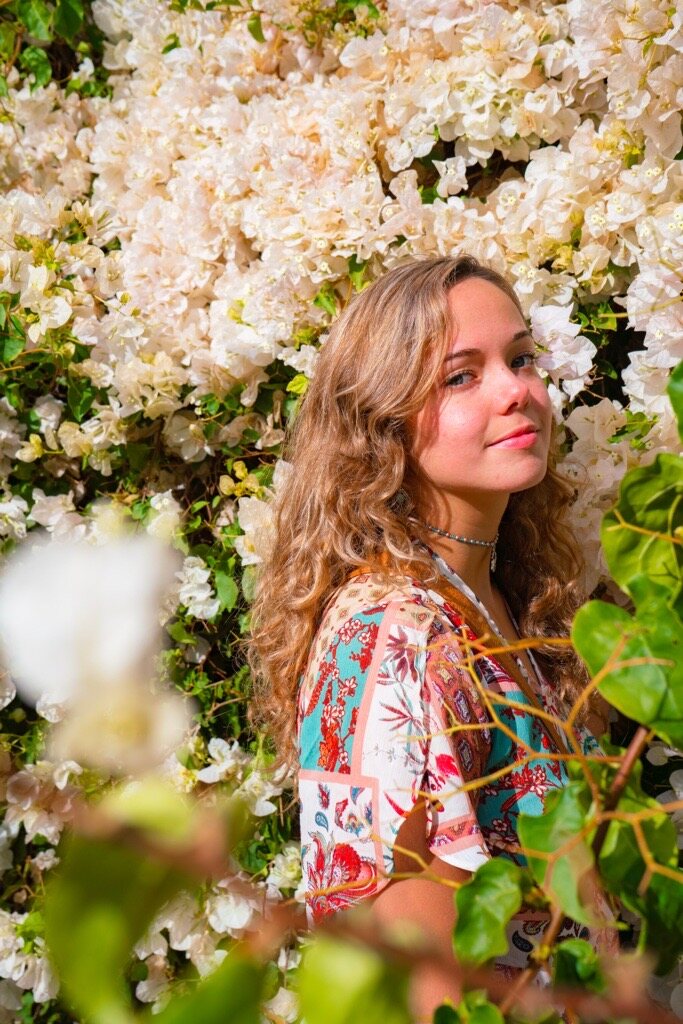 Portrait of Jade West among white flowers