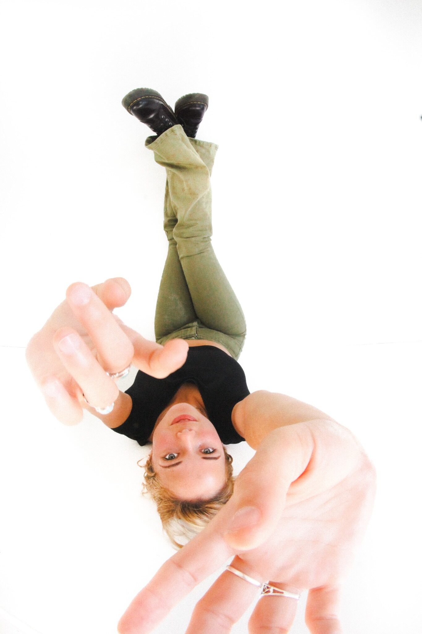 Woman playfully reaching toward the camera during a creative portrait session