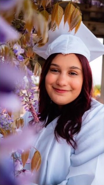 Graduate portrait beneath autumn leaves