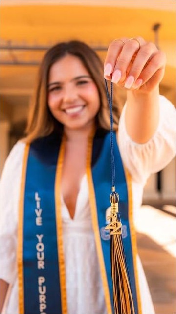 Graduate holding up her tassel