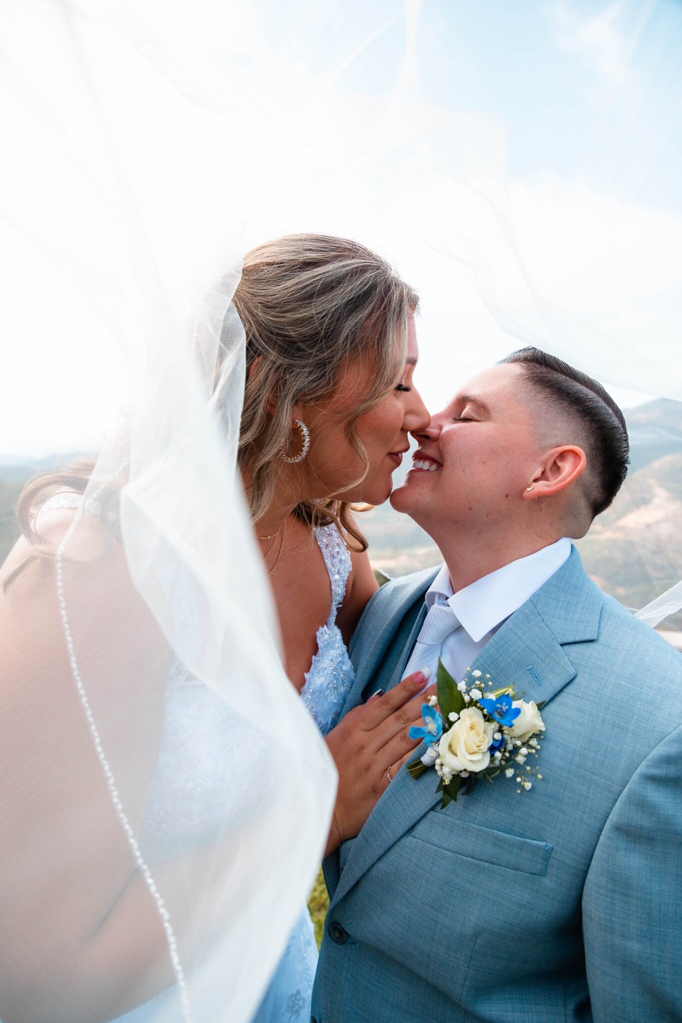 Wedding couple smiling beneath the bride's veil